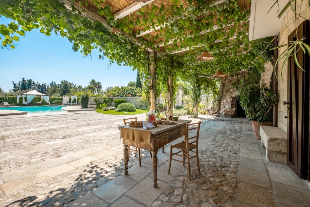 Area relax in Masseria con piscina in Puglia, ricoperta da una fitta vite con ottima uva